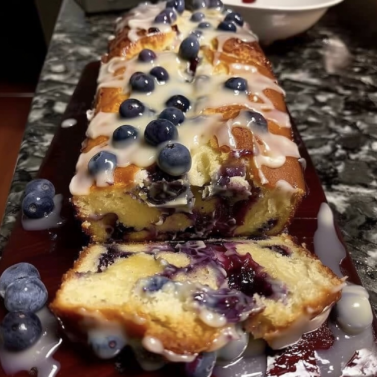 Lemon Blueberry Loaf drizzled with zesty lemon glaze.